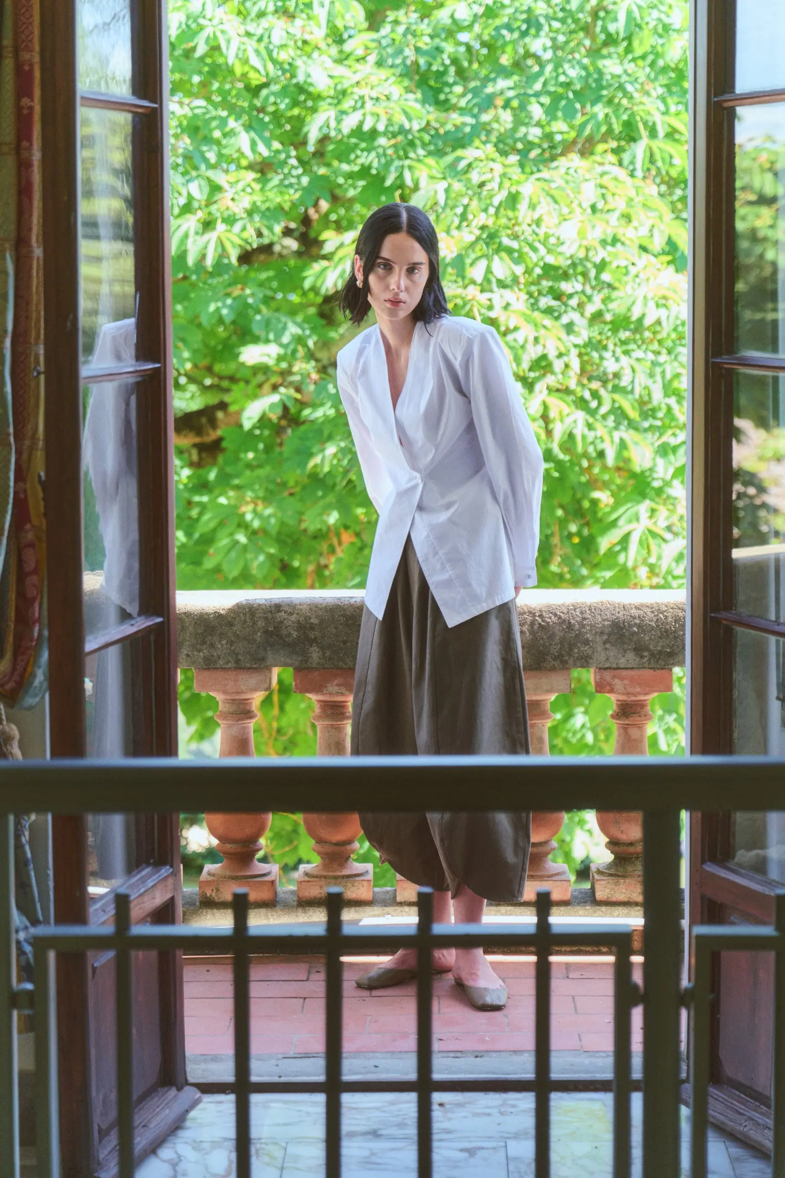 A woman in precise tailoring caught in bright summer light.