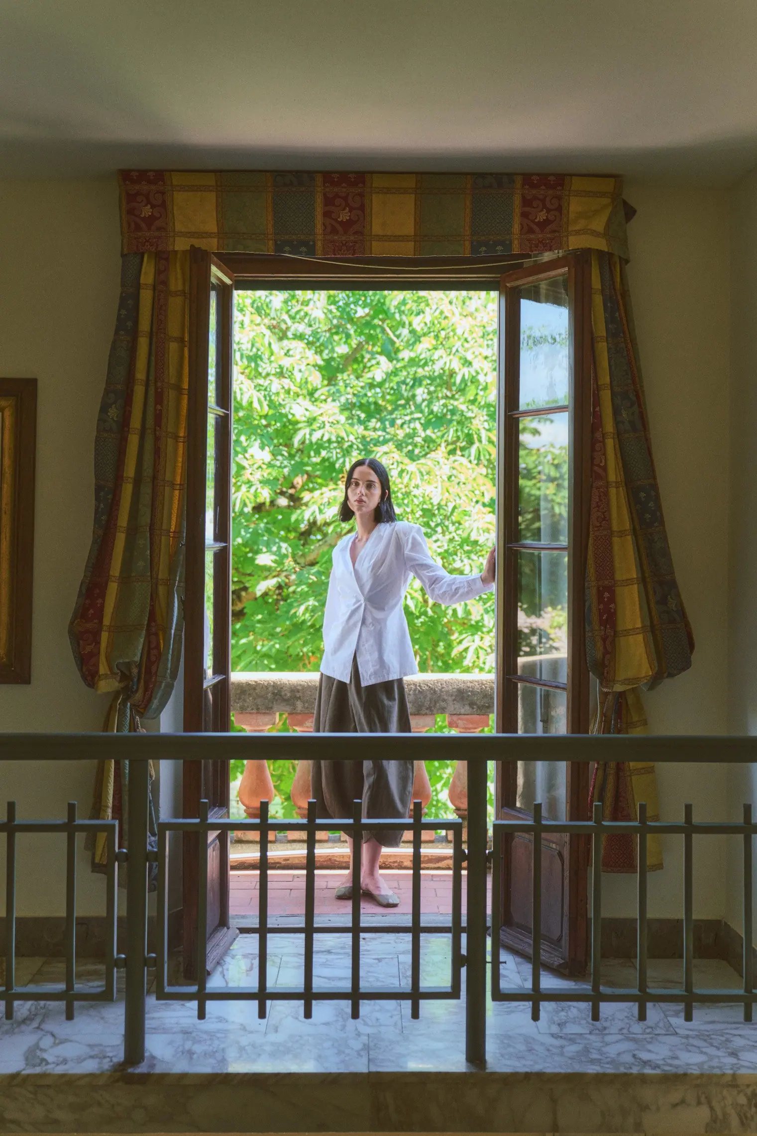 Portrait of the woman on a shaded loggia.